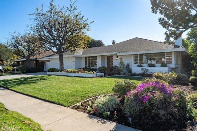 single story home featuring a front lawn and a garage