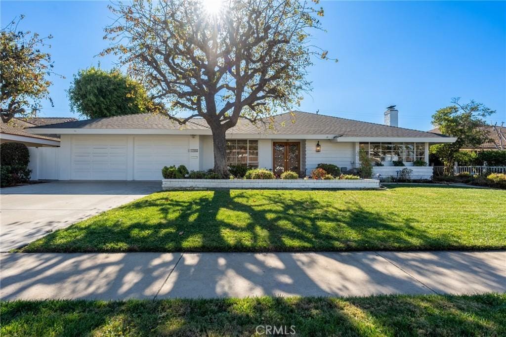 ranch-style home with a front yard and a garage