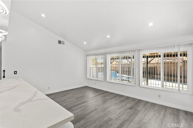 interior space featuring hardwood / wood-style flooring, vaulted ceiling, and plenty of natural light