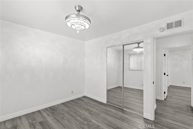 unfurnished bedroom featuring a closet and dark hardwood / wood-style floors