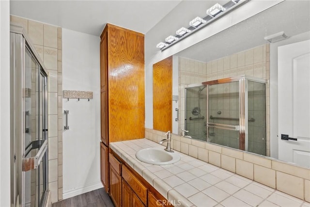 bathroom featuring an enclosed shower, vanity, and hardwood / wood-style floors