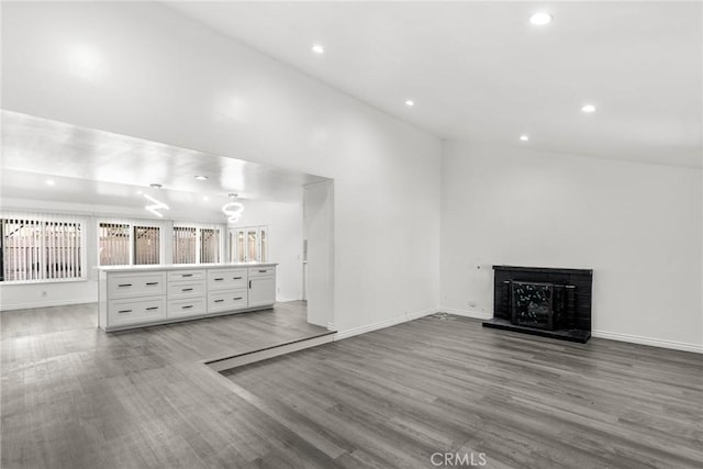 unfurnished living room featuring hardwood / wood-style floors and vaulted ceiling