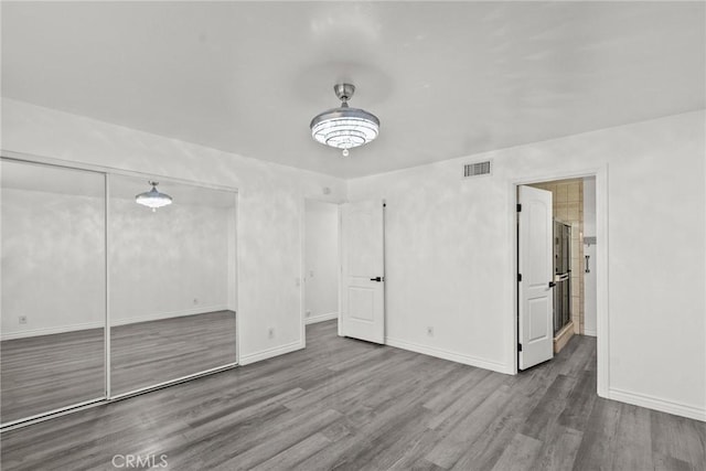 unfurnished bedroom featuring a closet and wood-type flooring