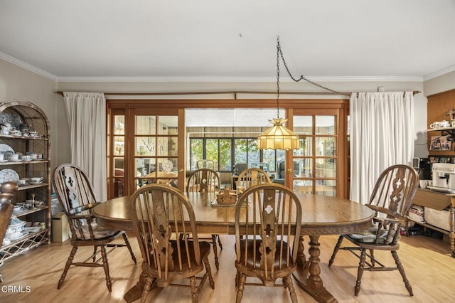 dining space featuring light hardwood / wood-style floors and crown molding