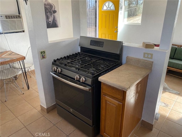 kitchen with gas range, light tile patterned flooring, and cooling unit