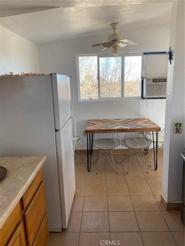 kitchen featuring ceiling fan, cooling unit, a textured ceiling, light tile patterned floors, and white refrigerator