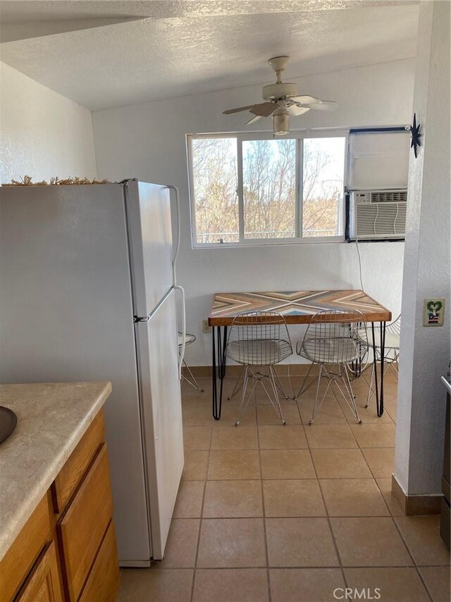 kitchen featuring ceiling fan, light tile patterned flooring, cooling unit, a textured ceiling, and white refrigerator