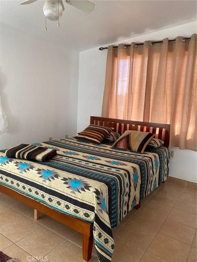 tiled bedroom featuring ceiling fan