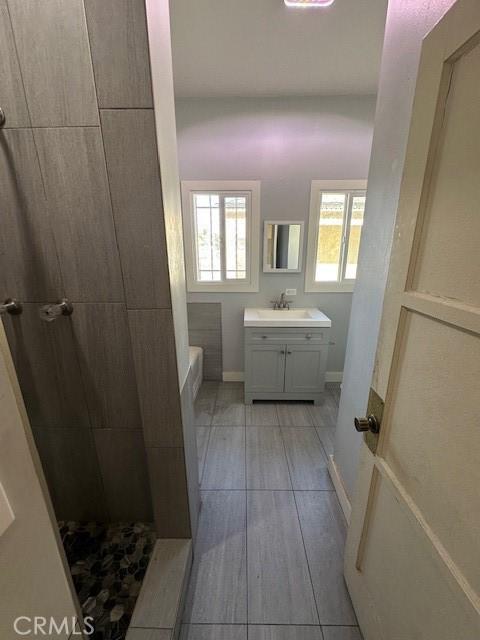 full bath featuring vanity, baseboards, tiled shower, a bath, and tile patterned floors