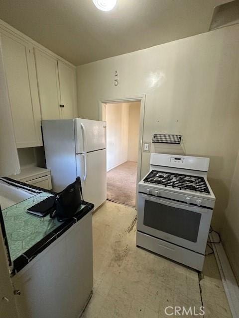 kitchen featuring tile countertops, white appliances, and white cabinets