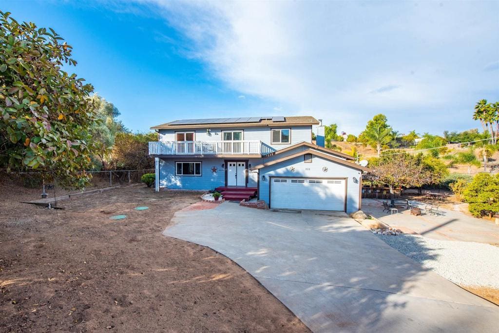 view of property featuring a balcony, a garage, and solar panels