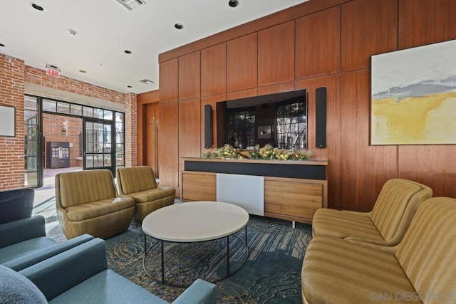 living room with brick wall and wood walls