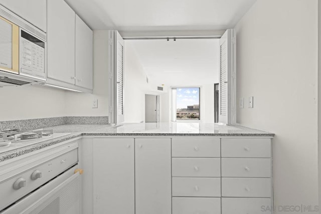 kitchen featuring white appliances and white cabinets