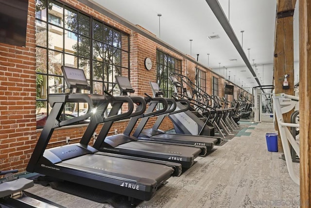 workout area featuring brick wall