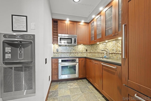 kitchen featuring appliances with stainless steel finishes, tasteful backsplash, and sink