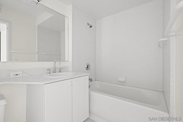 bathroom with tiled shower / bath combo and vanity