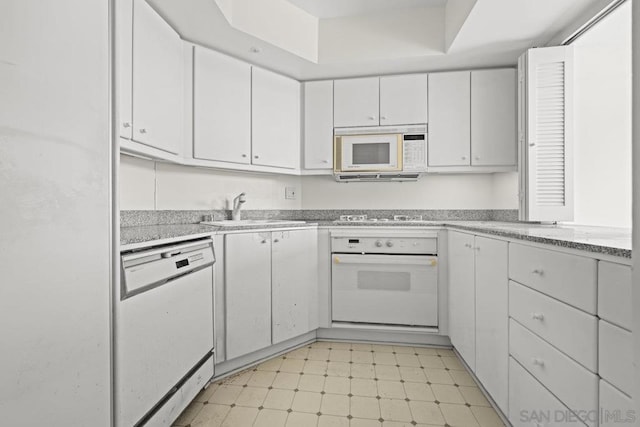 kitchen with white cabinetry, sink, and white appliances