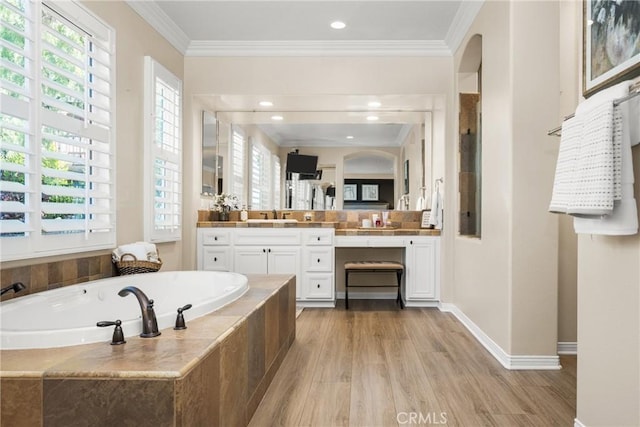 bathroom with tiled bath, crown molding, wood-type flooring, and vanity