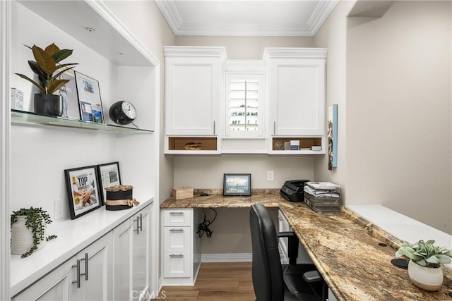 office space featuring built in desk, crown molding, and hardwood / wood-style flooring