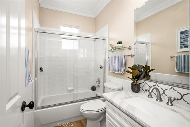 full bathroom featuring toilet, vanity, wood-type flooring, enclosed tub / shower combo, and ornamental molding