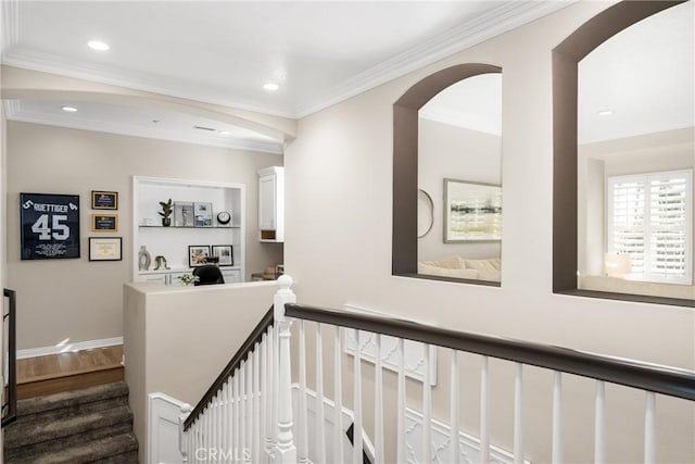 corridor featuring built in shelves and ornamental molding