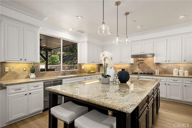 kitchen featuring sink, appliances with stainless steel finishes, an island with sink, and white cabinetry