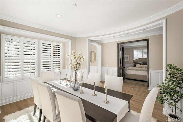 dining space featuring crown molding and light wood-type flooring