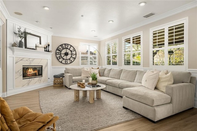 living room with a fireplace, ornamental molding, and hardwood / wood-style floors