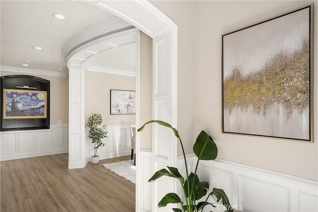 hall with ornamental molding and wood-type flooring