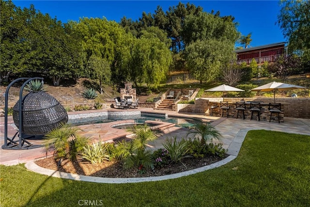 view of swimming pool featuring a lawn, a patio area, and exterior fireplace