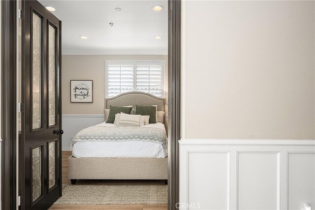 bedroom with crown molding and light hardwood / wood-style flooring