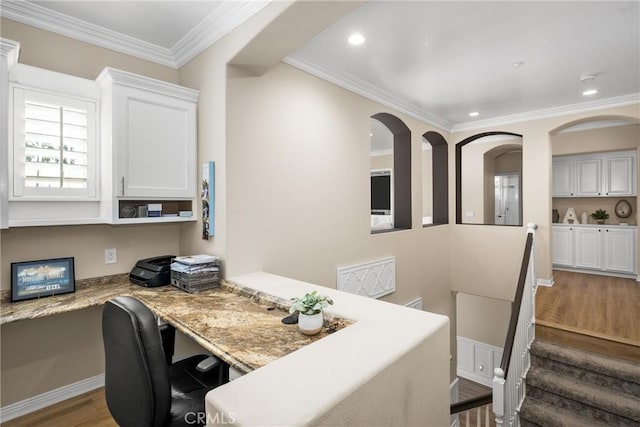 office area with built in desk, wood-type flooring, and ornamental molding