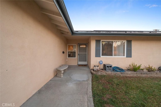 view of exterior entry featuring a yard