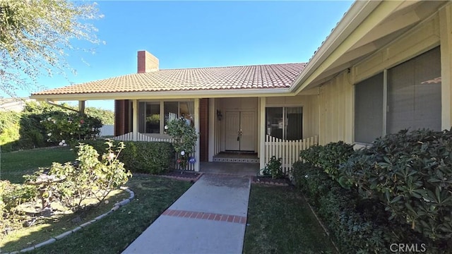 entrance to property featuring a lawn