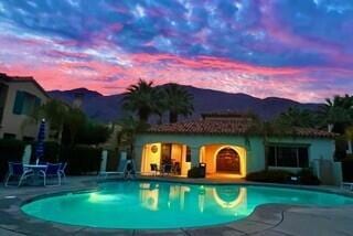 pool at dusk with a mountain view and a patio area