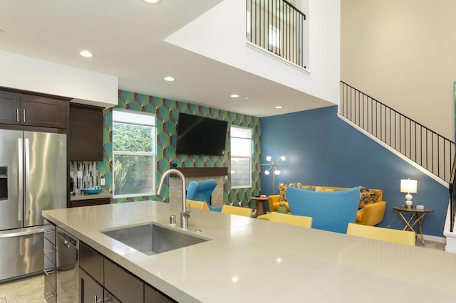 kitchen with a healthy amount of sunlight, sink, stainless steel appliances, and dark brown cabinetry