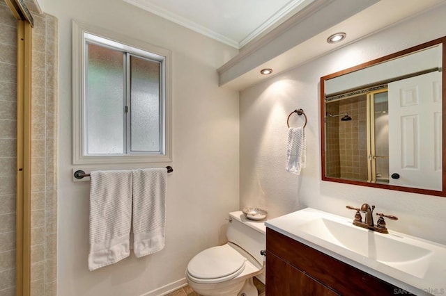 bathroom with a tile shower, vanity, ornamental molding, and toilet