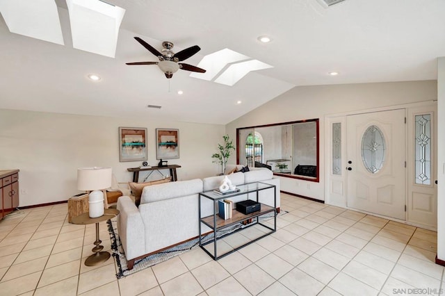 living room with ceiling fan, light tile patterned floors, and vaulted ceiling with skylight