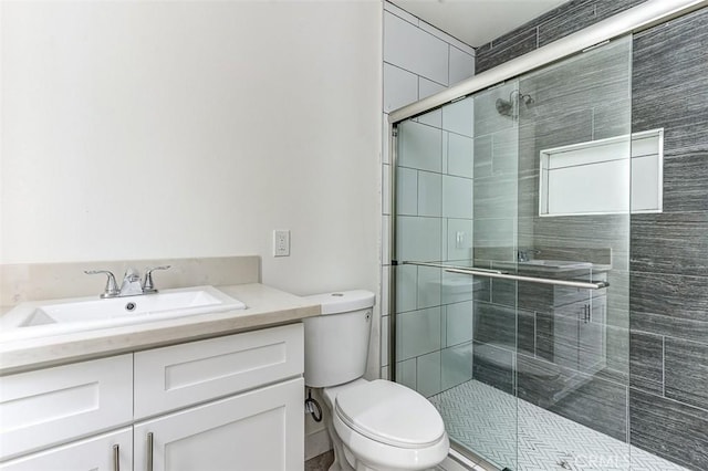full bath with vanity, a shower stall, and toilet