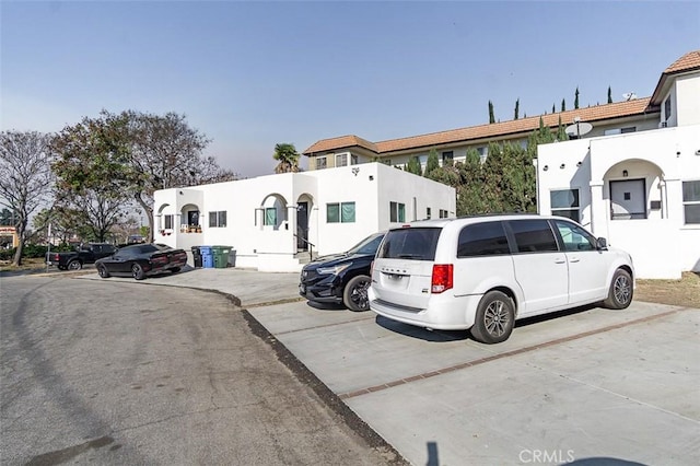 view of front of property with uncovered parking and stucco siding