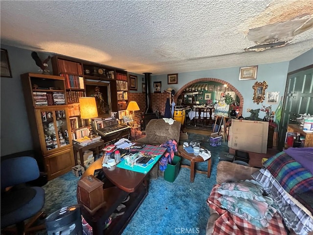 interior space with a textured ceiling, carpet flooring, and a wood stove