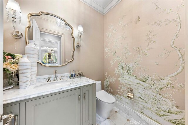 bathroom featuring toilet, vanity, and crown molding