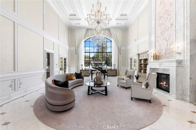 living room with a high ceiling, beamed ceiling, a premium fireplace, and coffered ceiling