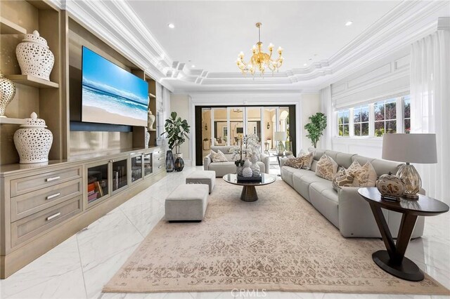 living room with ornamental molding, a chandelier, and a raised ceiling