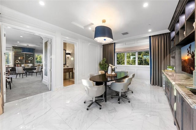 dining room featuring plenty of natural light and ornamental molding