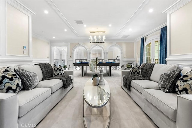 living room with an inviting chandelier and ornamental molding