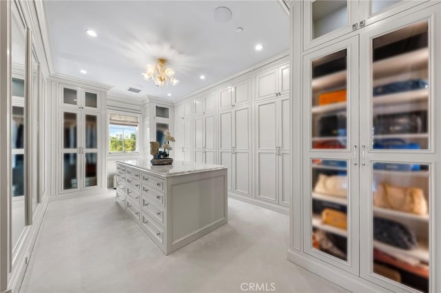 spacious closet with a notable chandelier