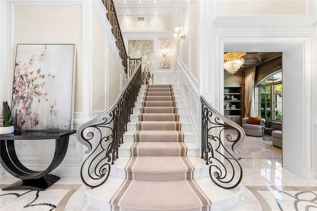 staircase featuring a chandelier and ornamental molding