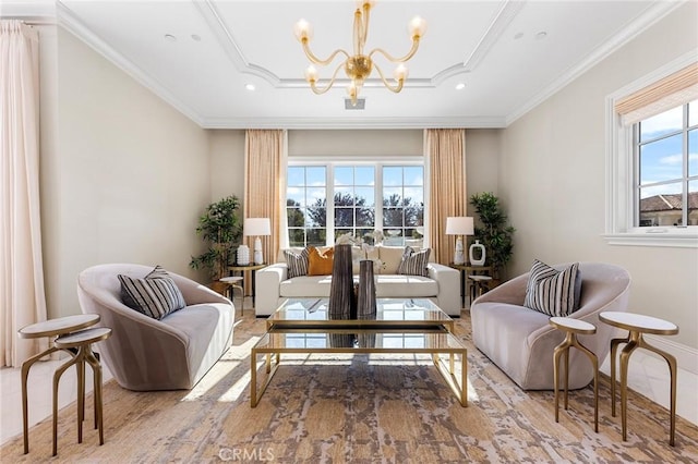 sitting room featuring a raised ceiling, ornamental molding, and a notable chandelier