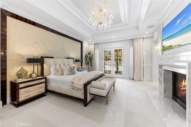 bedroom featuring french doors, a fireplace, access to exterior, a notable chandelier, and crown molding